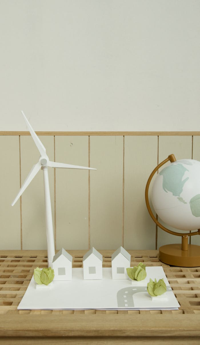 Home Vertical shot of a school project with miniature windmill and globe, symbolizing renewable energy.
